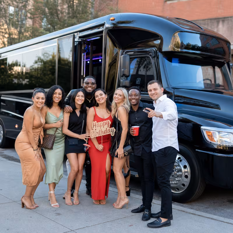 Group boarding a white charter bus for Birthday Transportation transportation in Anaheim