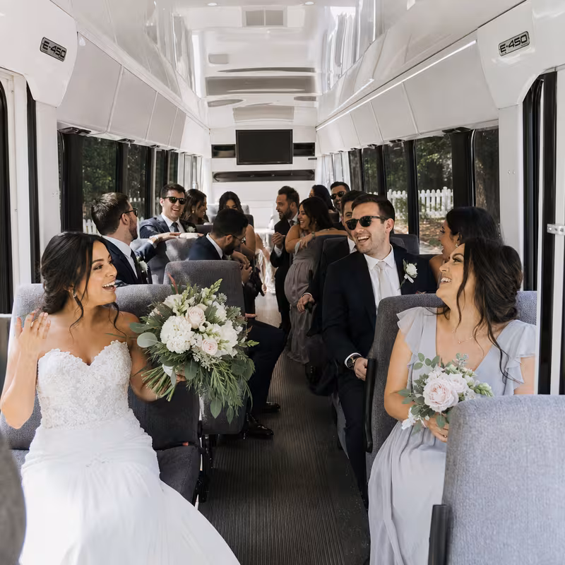 Group boarding a white charter bus for Wedding Transportation transportation in Anaheim